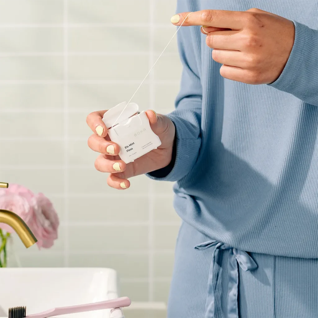 Person taking out boka floss ela mint