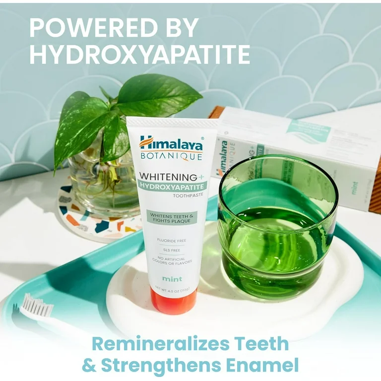 Himalaya Toothpaste powered by hydroxyapatite with a glass of liquid mint and a white toothbrush