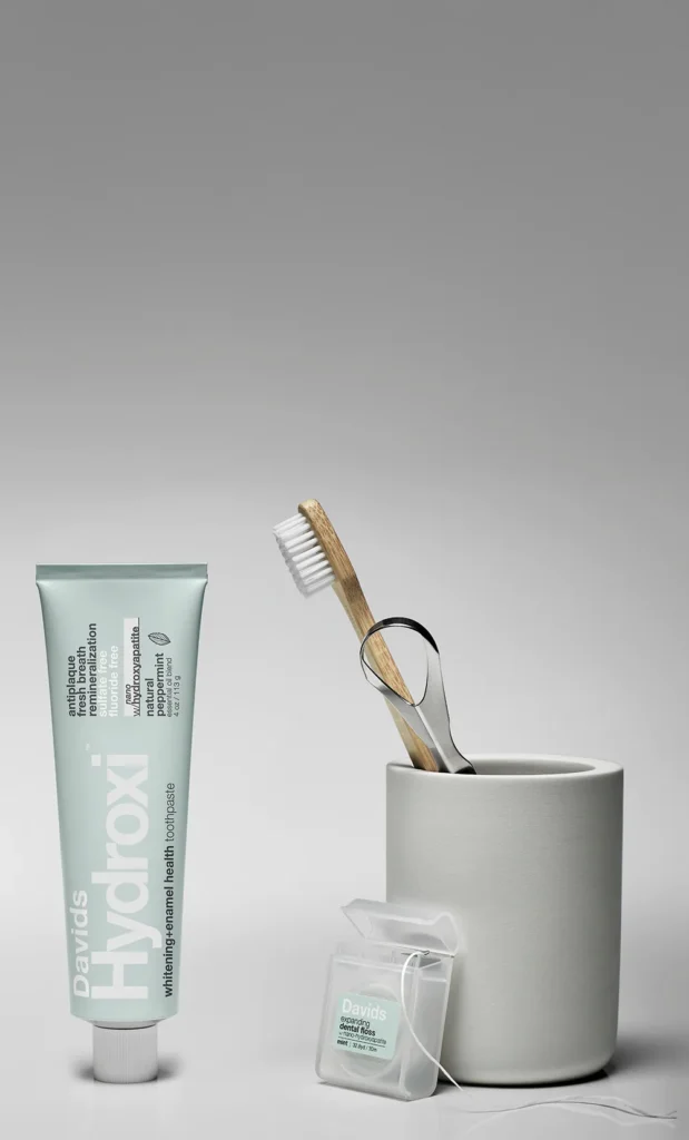 davids toothpaste with toothbrush on bathroom shelf for best oral care