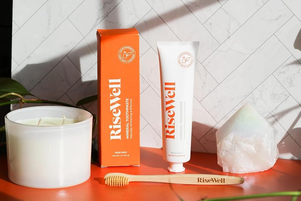 Risewell toothpaste on wooden table with a wooden toothbrush