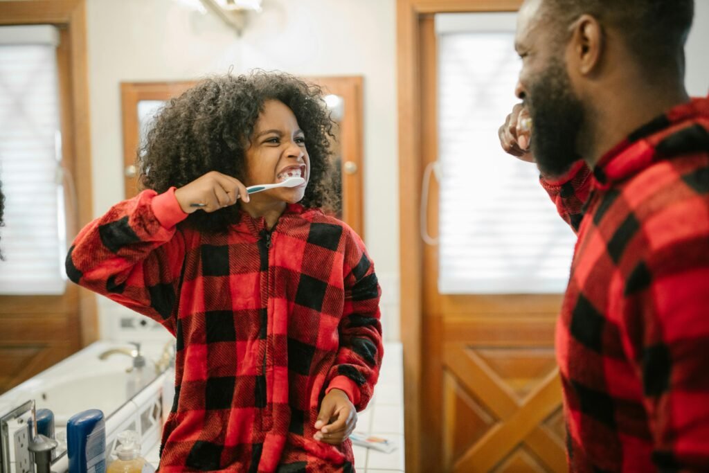 A child smiling while using Hello Dragon Dazzle Blue Raspberry toothpaste.