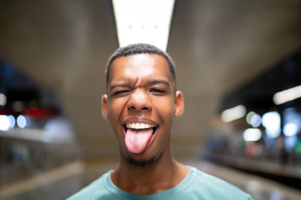 african american man after using copper tongue scraper with his tongue out