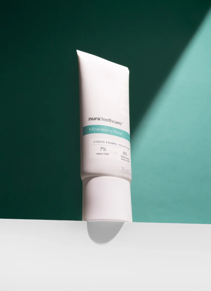nura toothpaste tube with green background