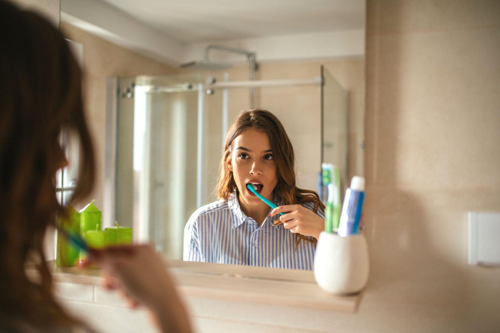 girl brushing teeth with electric toothbrush wondering can enamel grow back?